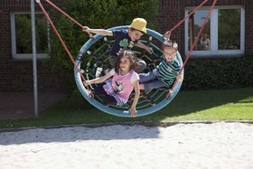 Kinder schaukeln auf dem Spielplatz