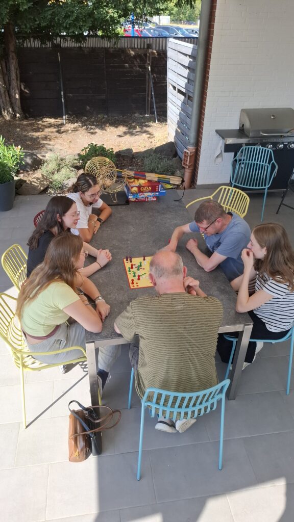 Schülerinnen spielen gemeinsam mit Bewohnern ein Gesellschaftsspiel.