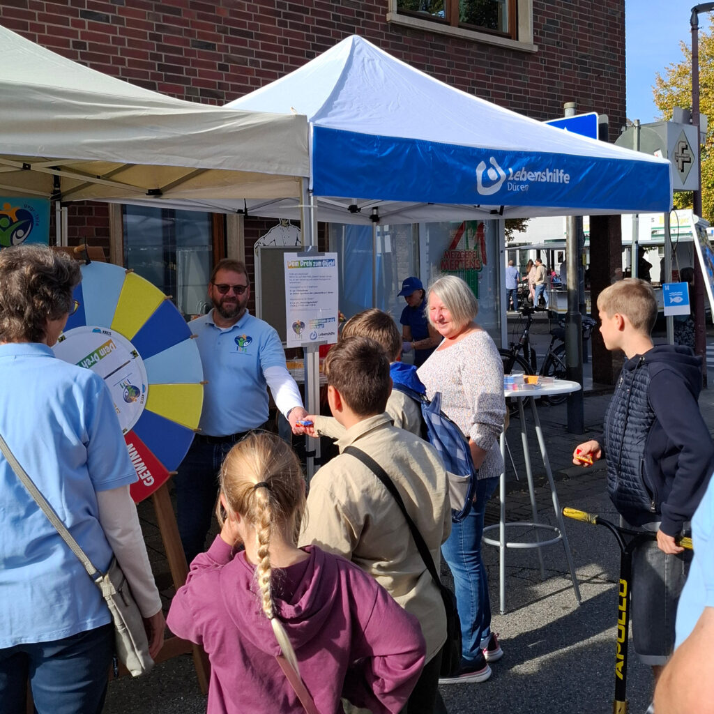 Klaus Breuer steht am Glücksrad des ISM Merzenich und der Lebenshilfe Düren beim Ortsfest in Merzenich.