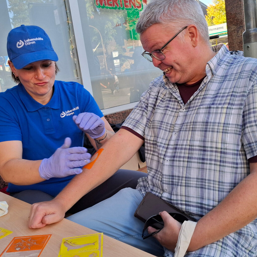 Mitarbeiter schminken sich beim Ortsfest in Merzenich.